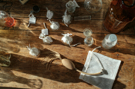 erfume bottles and glass vessels arranged on studio table in natural l