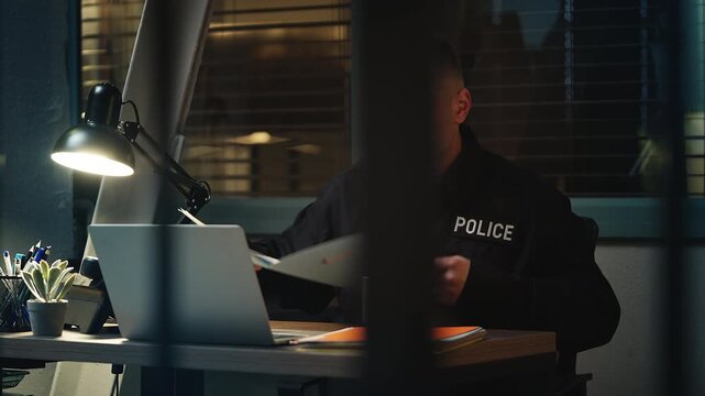 Middle-aged police officer feeling exhausted from office work during night shift