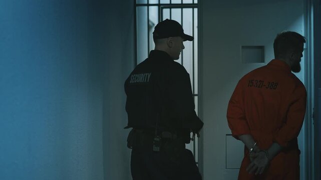 Prison guard removing handcuffs before placing an inmate into a solitary cell