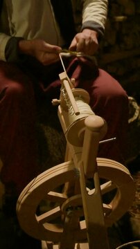 Artisan Spinning Wool with Traditional Wooden Tool at Christmas Fair &ndash; Vertical