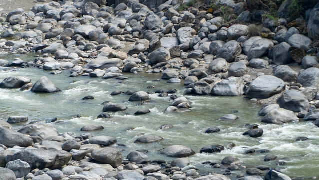Mountain Stream Flowing Through Rocky Riverbed in Natural Landscape

