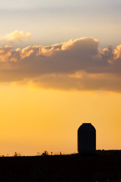 Silhouetted water tank against a dramatic golden sky in La Mancha