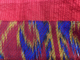 Obraz premium Close-Up of Red Quilted Cotton Fabric with Multicolor Ikat Woven Border