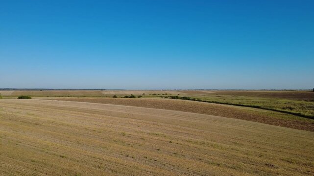 Panoramic Drone Shot Over Summer Farmland. Stunning Drone Aerial of Cultivated Fields and Green Vegetation.