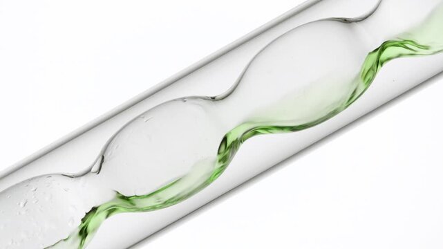 Big close up shot of green transparent fluid being poured and filling up inclined bulb lab condenser on white | Milk thistle tincture cosmetic science concept