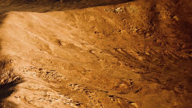 Rugged terrain stretches across the surface of a distant planet, with varied textures and colors. The area shows signs of geological activity and age. Shadows play across the landscape.