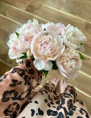 Woman is holding bouquet of fresh peonies © Natalia