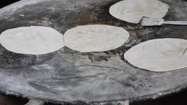 Flatbreads cooking on hot commercial griddle
