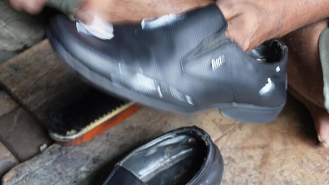Black leather formal shoe being hand polished