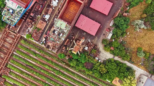Bird's eye view of a shipbuilding area with various buildings and structures. The land features show rows of materials and greenery surrounding the site.