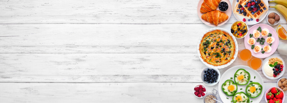 Breakfast or brunch side border on a white wood banner background. Top down view. Assorted fruits and sweet and savory food items. Copy space.