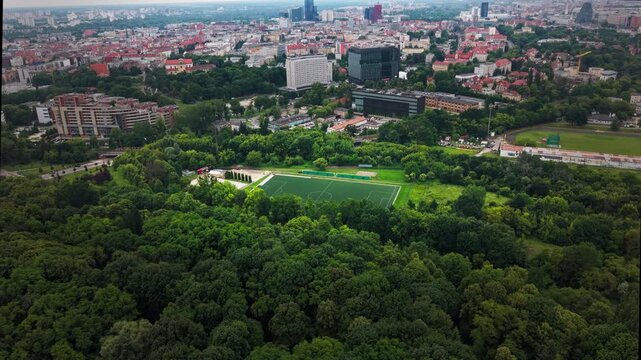 City Park Football Field Residential Buildings Skyline. Aerial View. A high angle drone perspective capturing a lush green urban park