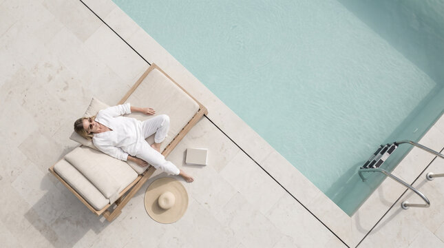 Woman Relaxing by Luxury Swimming Pool Aerial View