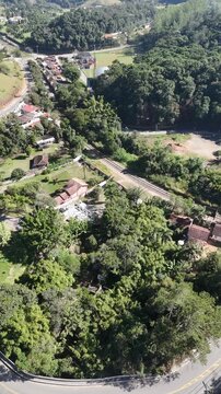 Vista superior de rota cicl&iacute;stica em Saba&uacute;na, com estrada sinuosa entre mata, campos e planta&ccedil;&otilde;es, destacando esporte, turismo rural e contato com a natureza em Mogi das Cruzes.