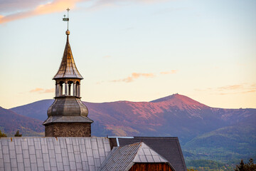 Kościół św. Marcina w Bukowcu na Dolnym Śląsku z widokiem na malowniczą panoramę Karkonoszy i Śnieżkę w krajobrazie Sudetów, po zachodzie słońca w Polsce © krzys ser