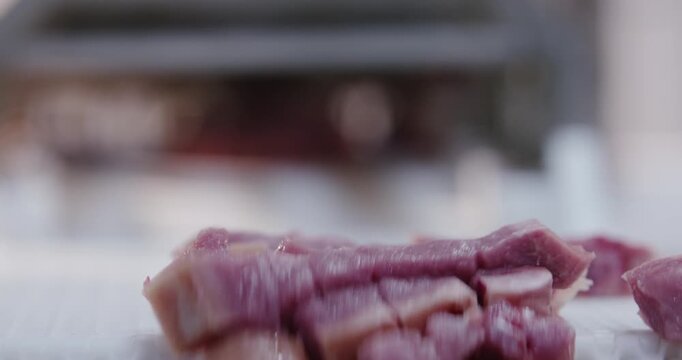 Raw meat cubes lying on a bright work surface in a kitchen