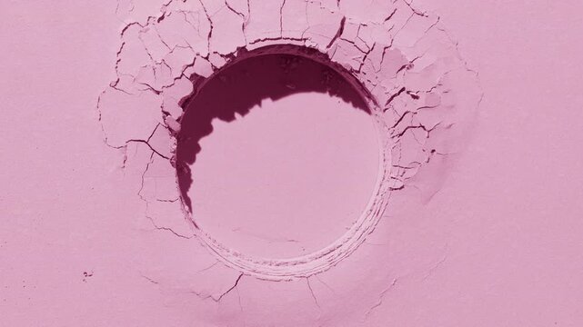 Top view shot of pastel pink level powder surface with round imprint lit by orbiting light source that projects changing shadows | Ad concept for blush