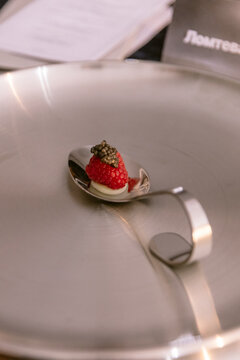 Dessert with fresh strawberry served on elegant fine dining spoon