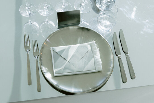 Restaurant table setting with plates cutlery and crystal glasses