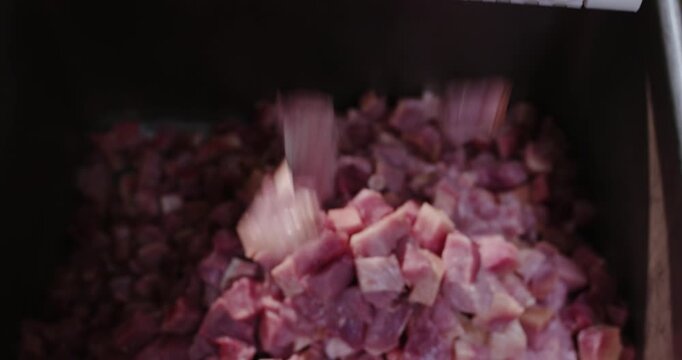 Diced raw pork falling from modular conveyor belt