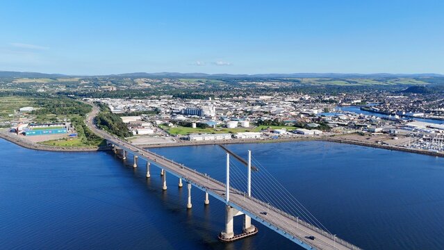 Inverness, Scotland, British city at daytime displays a bridge centered over the water, with sea views and clouds across Highland scenery.