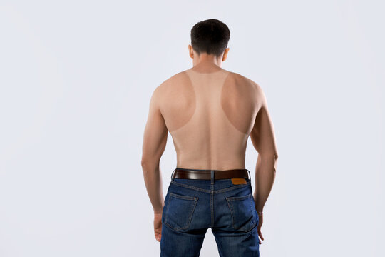 Man with suntan lines left after wearing sleeveless shirt, back view. White background