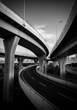 Curved highway ramps in black and white vertical view.