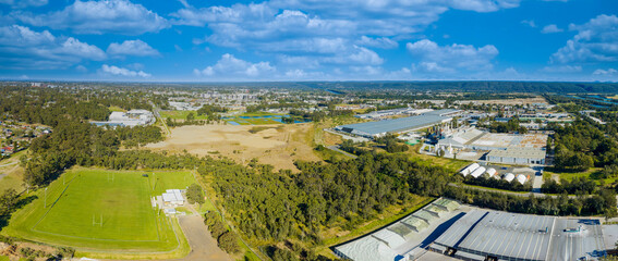 Drone aerial panoramic photograph of industrial buildings and a sports field surrounded by trees and foliage in the Greater Western Sydney town of Penrith in New South Wales, Australia © Phillip Wittke