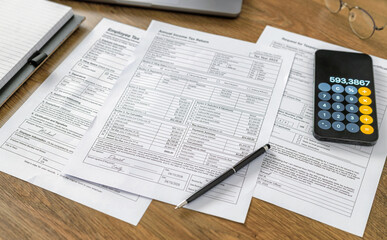 Fototapeta premium Tax Forms With Smartphone Calculator On Desk