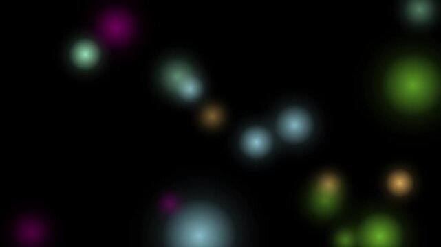 A seamless loop of glowing multicolored bokeh lights floating against a black background.