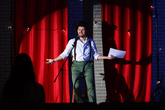Male actor with film script acting on stage during audition
