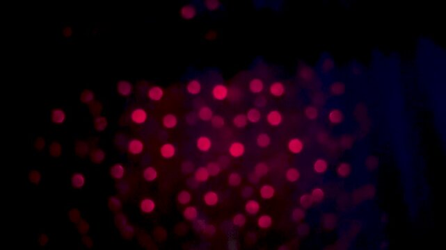Abstract image of red bokeh lights against a dark background creating a mysterious atmosphere
