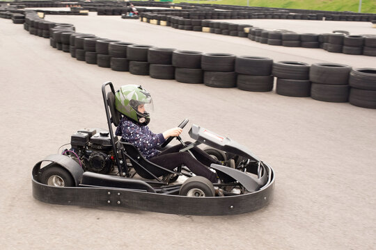 Karting event at a track with participants racing and wearing helmets