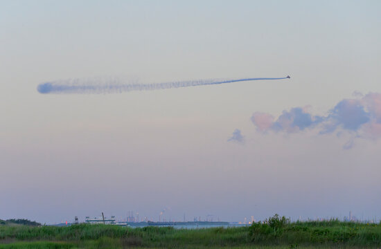 Aerial mosquito treatment from a plane at dawn over Galveston Island wetlands prior to the July 4 gathering, Galveston, Texas, USA.