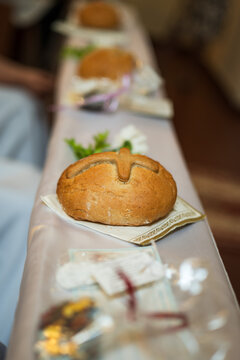 Traditional communion bread arranged on church pew during First Holy Communion ceremony, symbolizing Eucharist and Christian faith