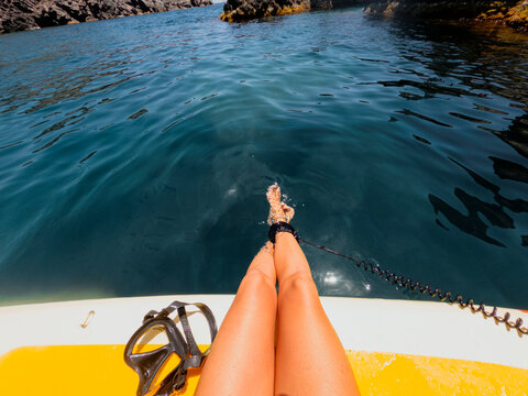Woman Relaxing on Paddle Board Above Crystal Clear Blue Water