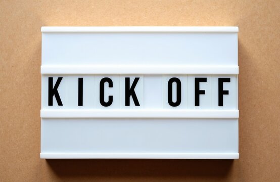 Lightbox displays the words Kick Off on a brown textured background. It signifies a new beginning, project launch, or event start. Use this for business, sports, or motivational content.