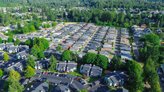 High density residential blocks follow repeating architectural pattern with strategic placement of community trees provides natural shading for all nearby suburban family homes in Kent, Washington