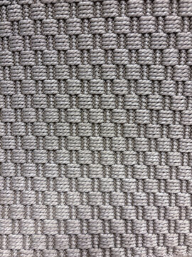 Gray and beige geometric woven carpet texture with repeating square loops and textile pattern