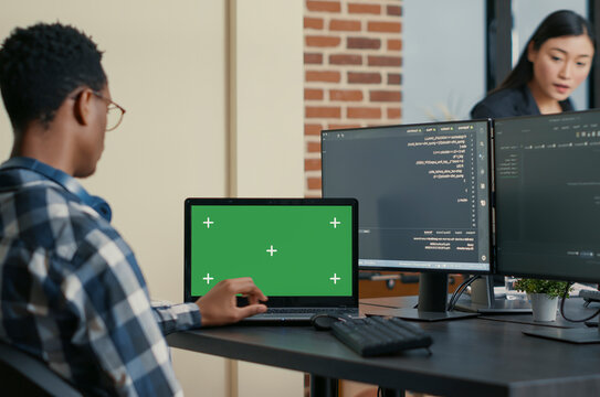 Database Designer Coding with Laptop Mockup uses a laptop chroma key screen in a software development workspace, with blank copy space and isolated mockup background for editable screen replacement.