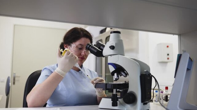 Medical laboratory specialist prepares a sample for microscopic examination by carefully transferring liquid onto a microscope slide with a pipette.