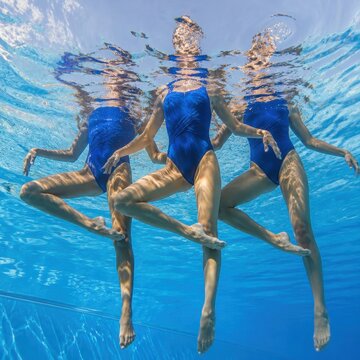 Synchronized Swimming Underwater. Female Swimmers Swimming Competition in Swimming Sport Pool. Artistic Swimming Women. No face.
