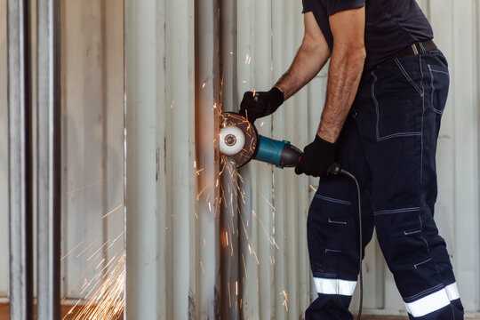 Man cutting shipping container with circular saw