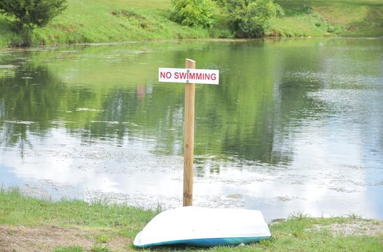 No Swimming Sign and Kayak by a Lake