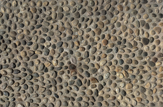 cobblestone paving texture with river pebbles set in mortar close-up 