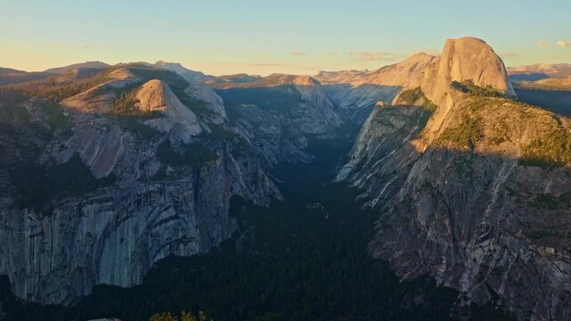 Golden sunset light bathes Half Dome as seen from Glacier Point in Yosemite
