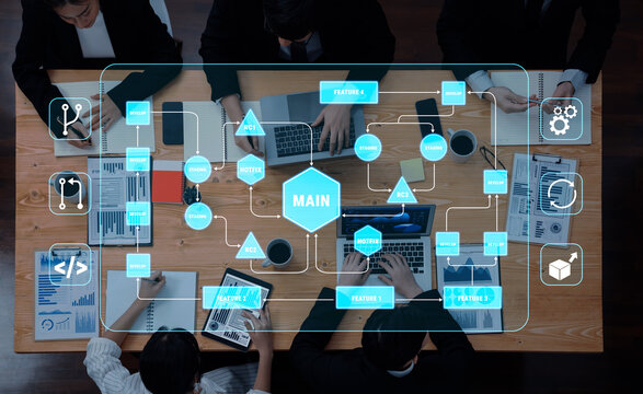 Overhead View of Business Team Collaborating on Innovative Project with Digital Interface and Charts on Wooden Desk Quark.