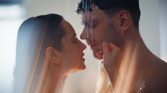 Passionate couple embracing shower water. Close up wet lovers touching tenderly.