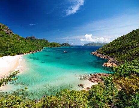 sunlit turquoise bay with white sand lush green mountains and rocky shores