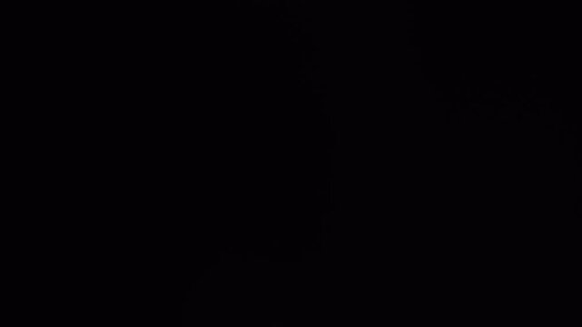 Abstract dark background with light flare and smoke transition.